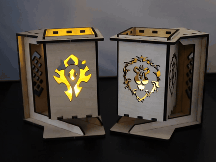 Two laser cut wooden lanterns lit from inside, one cut with the Horde crest and one with the Alliance crest.
